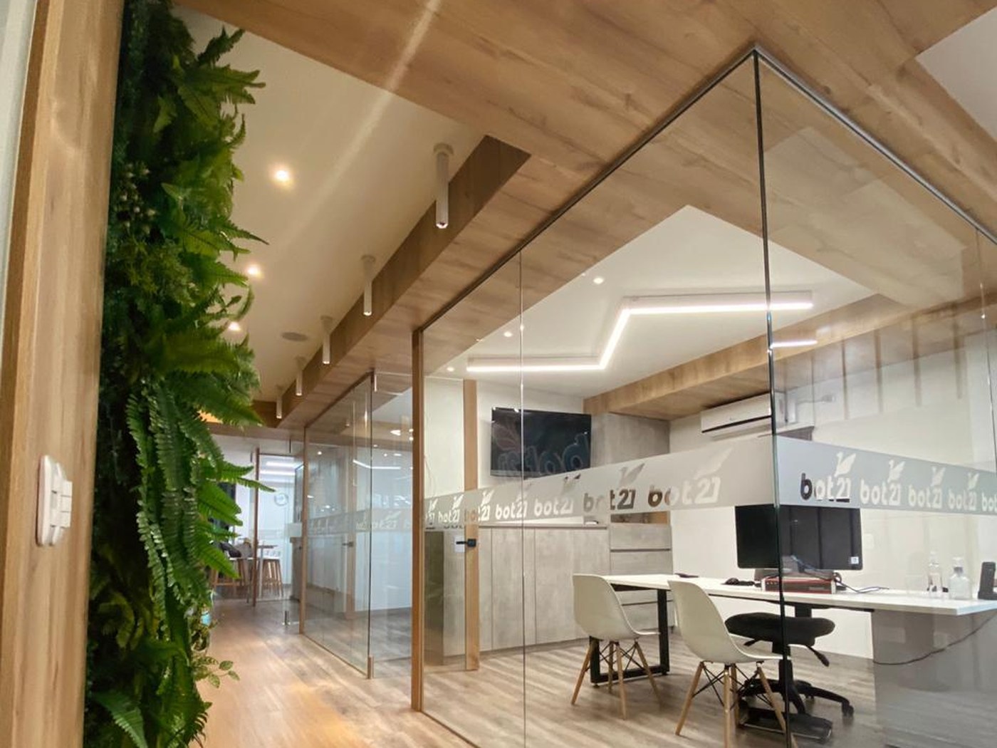 Oficinas con muro verde y divisiones en vidrio