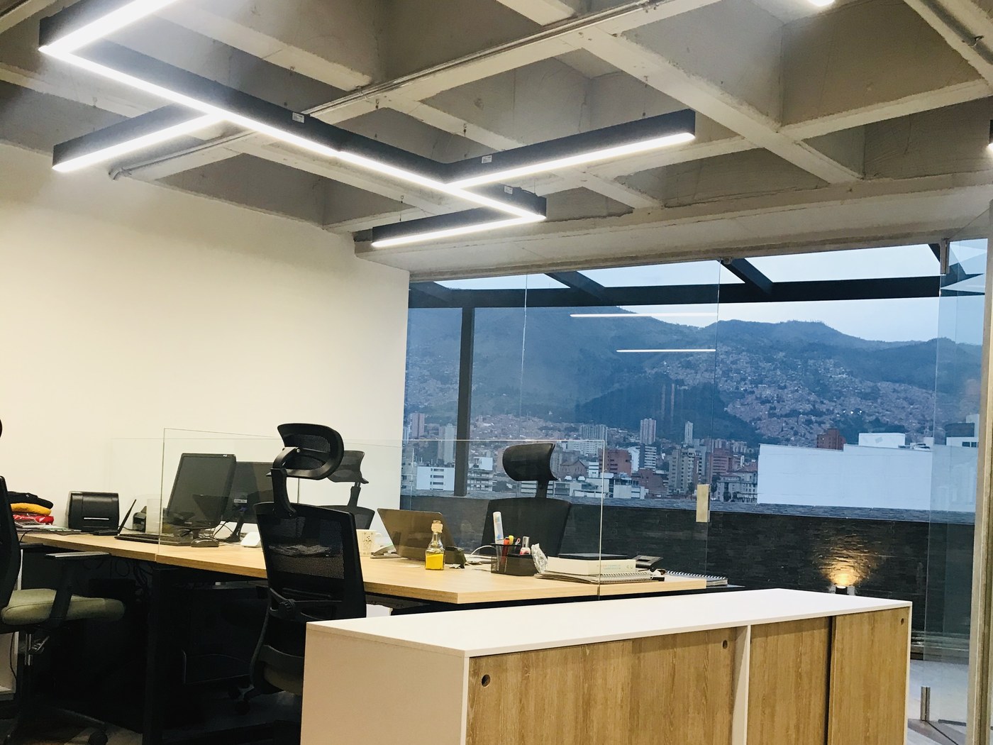 Oficinas de planta abierta con losa aligerada a la vista y vista a Medellín